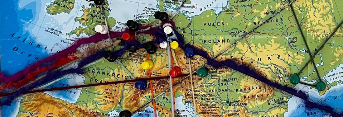 Map section of Western, Central and Eastern Europe (from Spain/Great Britain to Ukraine), on which different colored pins are connected by different colored wool threads.