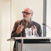Homi Bhabha gives a lecture at the lectern of the Akademie der Künste Berlin