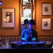 DJ Saeko Killy am Mischpult, von blauem Licht angestrahlt.