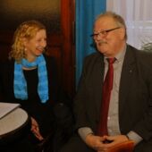 Halina Hackert und Fritz-Dieter Kupfernagel sitzen am Vortragspult, beide lächeln