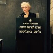 Sigrid Weigel stands behind a lectern with Hebrew inscription at the Minerva Institute for German History at Tel Aviv University