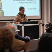 Jutta Koch-Unterseher stands at the lectern and speaks to the audience.