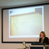 Totale von Franziska Thun-Hohenstein bei ihrer Rede vor ihrer an die Wand projizierten Präsentation
