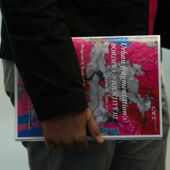 A participant holds an event brochure in his hand, the title: “Urban fragmentation(s). BORDERS & IDENTITY III”