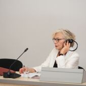 Sigrid Weigel listens to the introductory speech via a headset