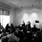 Schwarz-Weiß-Fotografie der Jonas Lüscher und Patrick Hohlweck. Die beiden diskutieren auf einem Podium vor einer Publikumsmenge.