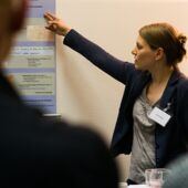 Hannah Markus gives a lecture while pointing to a poster